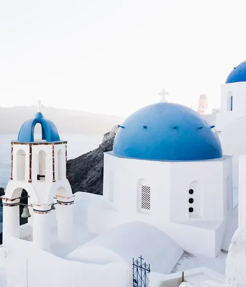 White chapels with blue domes above the sea