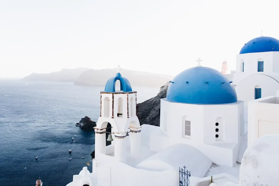 White chapels with blue domes above the sea
