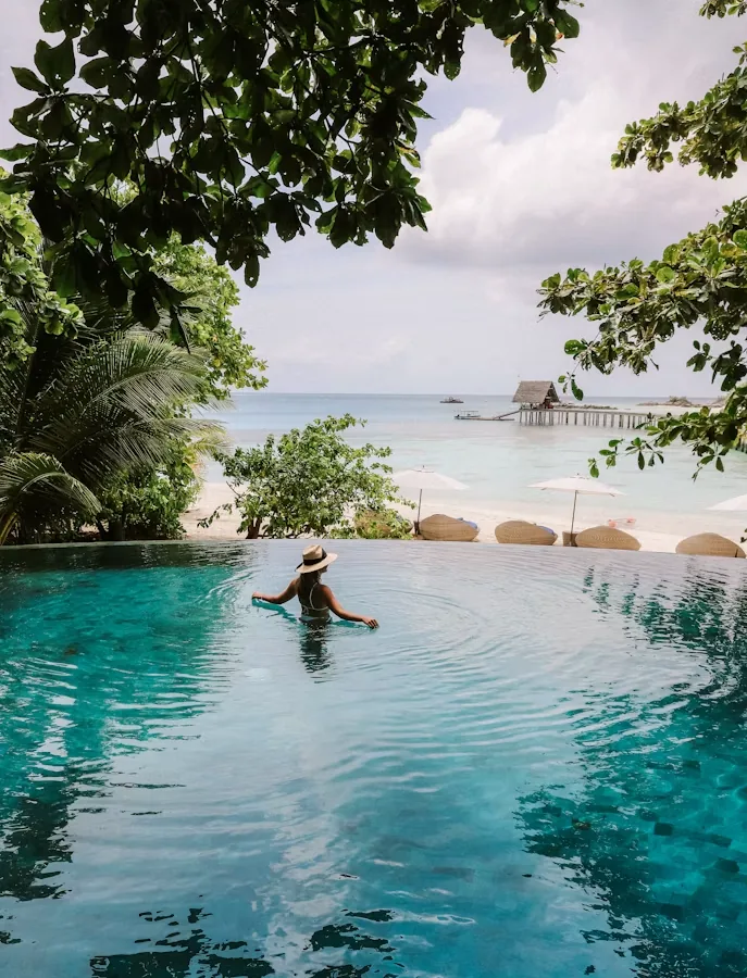 Traveller relaxing in an infinity pool in the Maldives